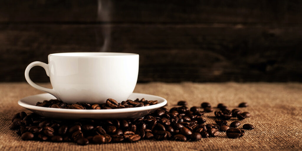 Caffè e tazzina bianca di ceramica, coppia inossidabile